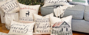 Decorative Christmas pillows on a couch with a Christmas tree in the background
