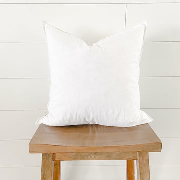 White square goose-down feather pillow insert on a wooden stool