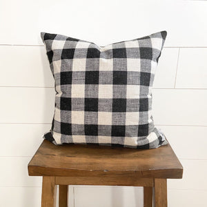 Black & White Medium Buffalo Plaid 18 by 18 inch pillow cover displayed on a stool  