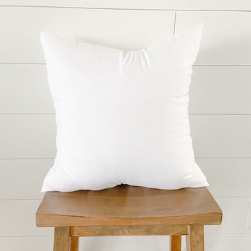 White square faux-down pillow insert on a wooden stool