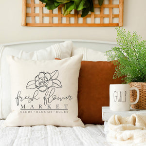Decorative spring pillow cover fresh flower market layered with other pillows on bed