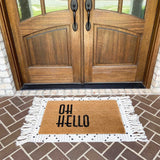 Oh Hello Mat On Top of Woven Decorative Indoor Rug 36x24 inches with White and Black Tassle Pattern on Porch