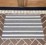 White and black horizontal stripe entry rug displayed on porch