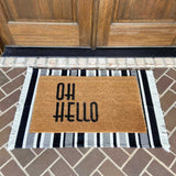 White with black vertical stripe entry rug layered with grass door mat displayed on porch