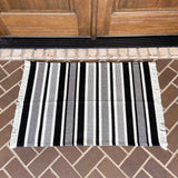 White with black vertical stripe entry rug displayed on porch